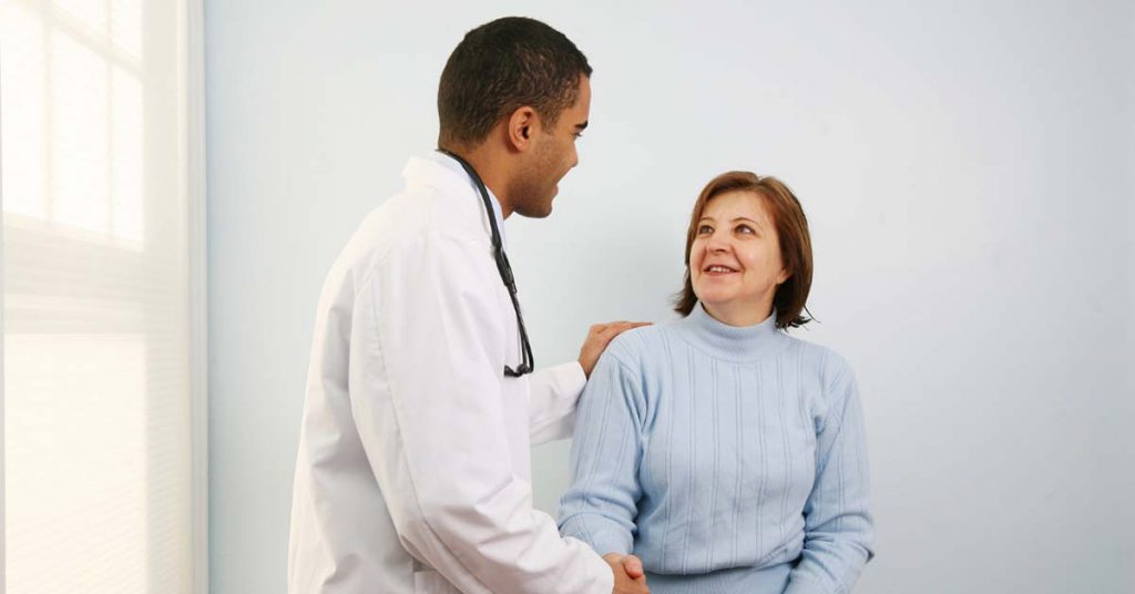 Médico atendendo paciente com cordialidade, representando confiança e autoridade para médicos na experiência da consulta.